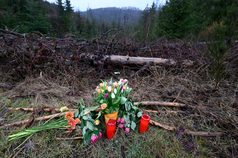Flowers and candles have been placed in a wooded area near where the body was found in Freudenberg, Germany (Roberto Pfeil/dpa via AP)