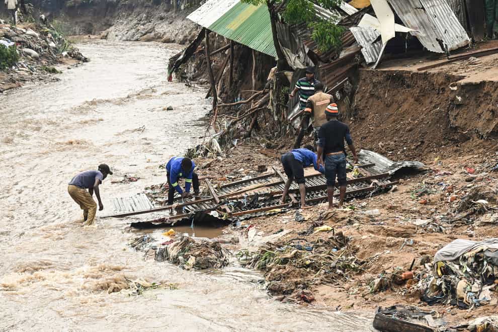 Men salvage parts from their destroyed home, following heavy rains caused by Cyclone Freddy in Blantyre, southern Malawi, Wednesday, March 15, 2023. After barreling through Mozambique and Malawi since late last week and killing hundreds and displacing thousands more, the cyclone is set to move away from land bringing some relief to regions who have been ravaged by torrential rain and powerful winds. (AP Photo/Thoko Chikondi)