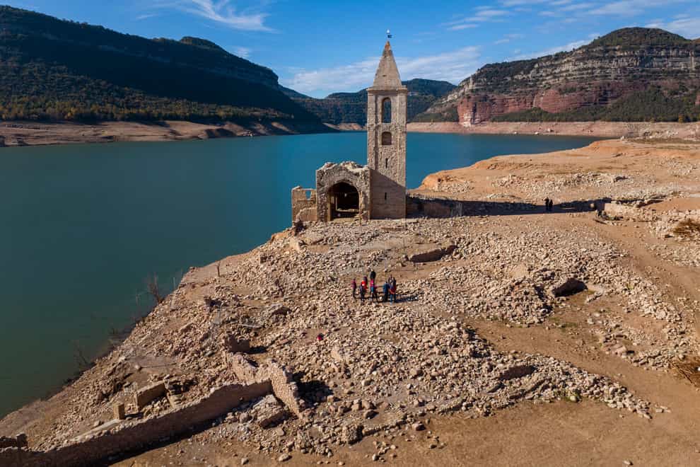 A church and remains of an ancient village which are usually covered by water are seen inside the reservoir of Sau, in Vilanova de Sau, Catalonia, in November 2022 (Emilio Morenatti/AP)