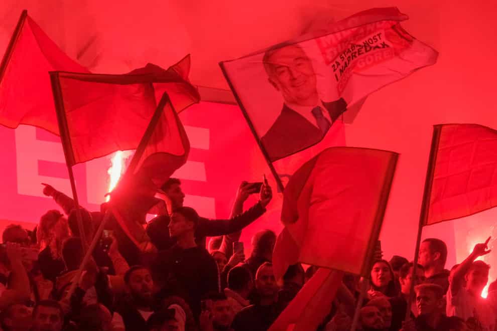 Supporters of pro-Western incumbent Milo Djukanovic cheer during a pre-election rally in Podgorica, Montenegro (Risto Bozovic/AP)