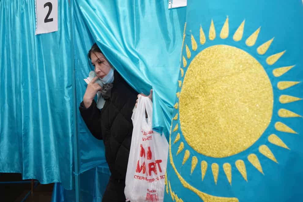 A woman leaves a voting booth after casting her ballot at a polling station in Almaty, Kazakhstan (Vladimir Tretyakov/NUR.KZ via AP)