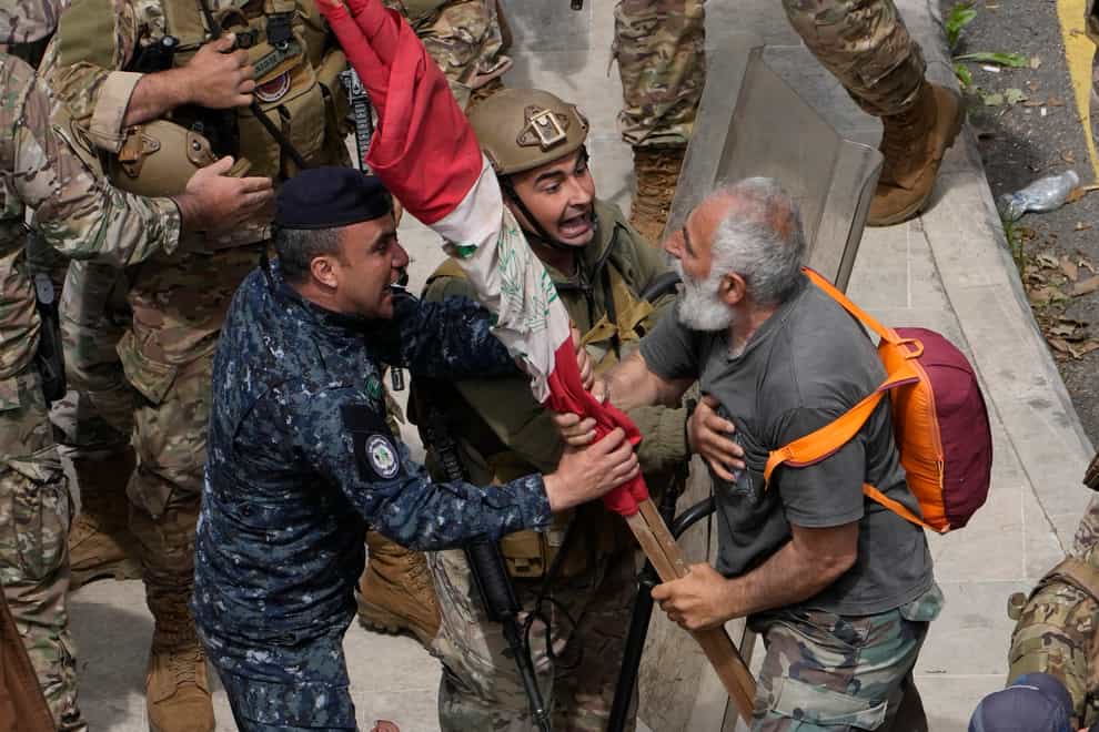 Retired soldiers and policemen clashed with riot police and troops in Beirut as they demanded better pay (Hussein Malla/AP)