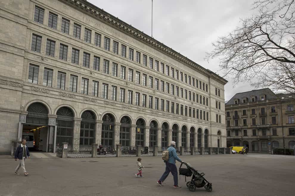 People walk past the facade of the Swiss National Bank in Zurich (Michael Buholzer/Keystone/AP)