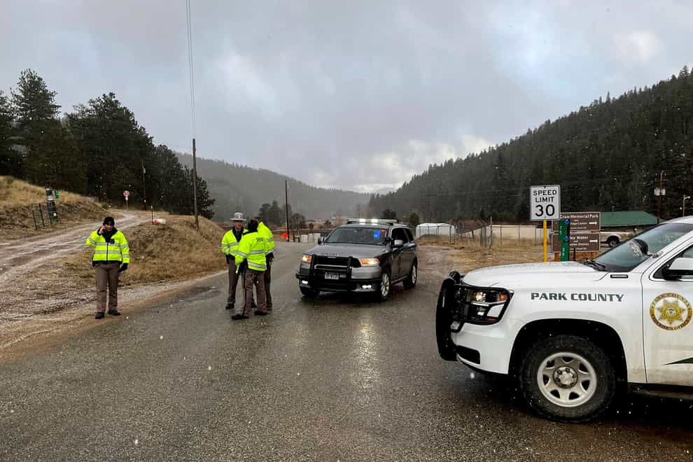 Authorities block a road in the town of Bailey, Colorado, where authorities found an abandoned car belonging to the suspect in a shooting of two administrators at a Denver school (Thomas Peipert/AP)