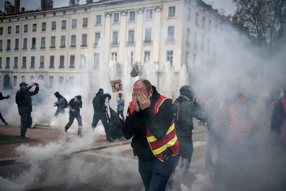 Protesters run amid the tear gas during a demonstration in Lyon (AP Photo/Laurent Cipriani)