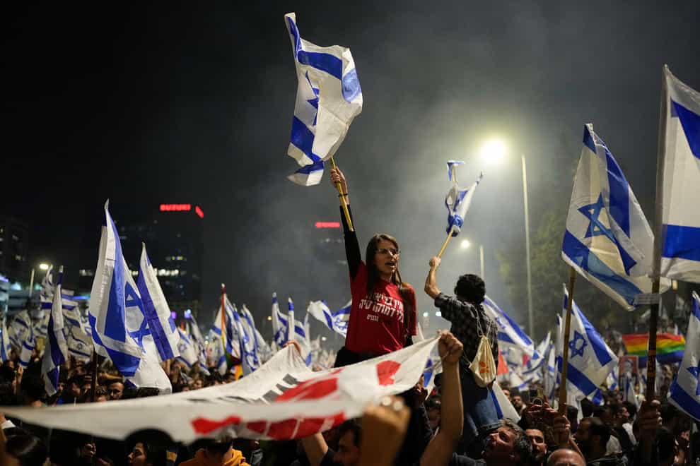 Israelis opposed to Prime Minister Benjamin Netanyahu’s judicial overhaul plan block a highway during a protest moments after the Israeli leader fired his defence minister, in Tel Aviv, Israel (Ohad Zwigenberg/AP)