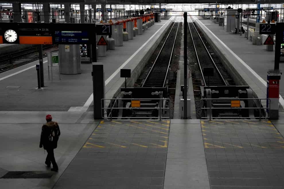 A man passes deserted railway platforms at the central station during a nationwide public transport strike in Munich (AP)