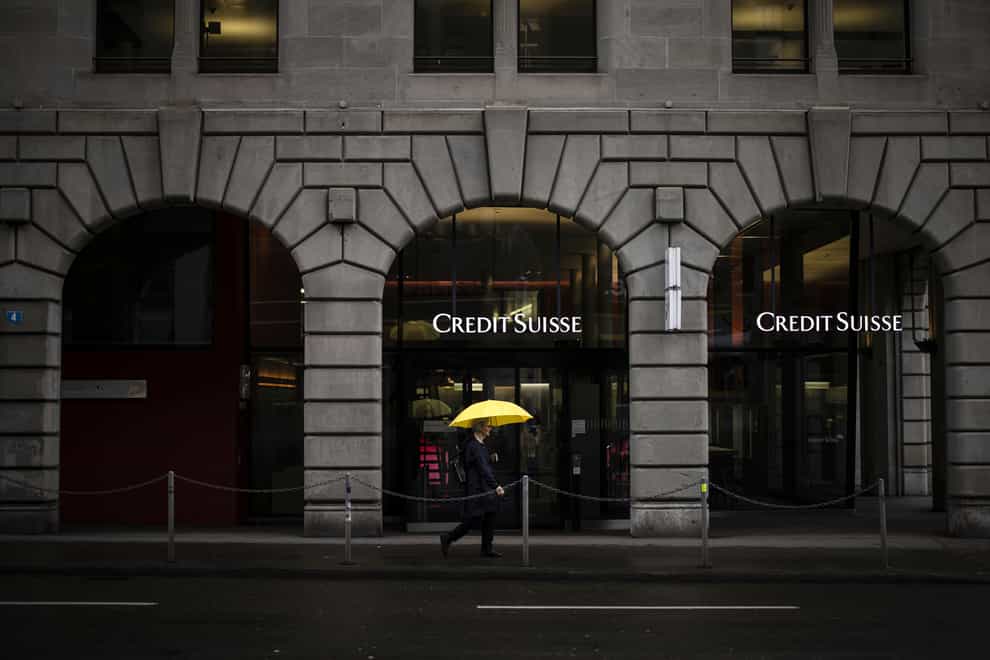A person walks past a logo of the Swiss bank Credit Suisse in Zurich (AP)
