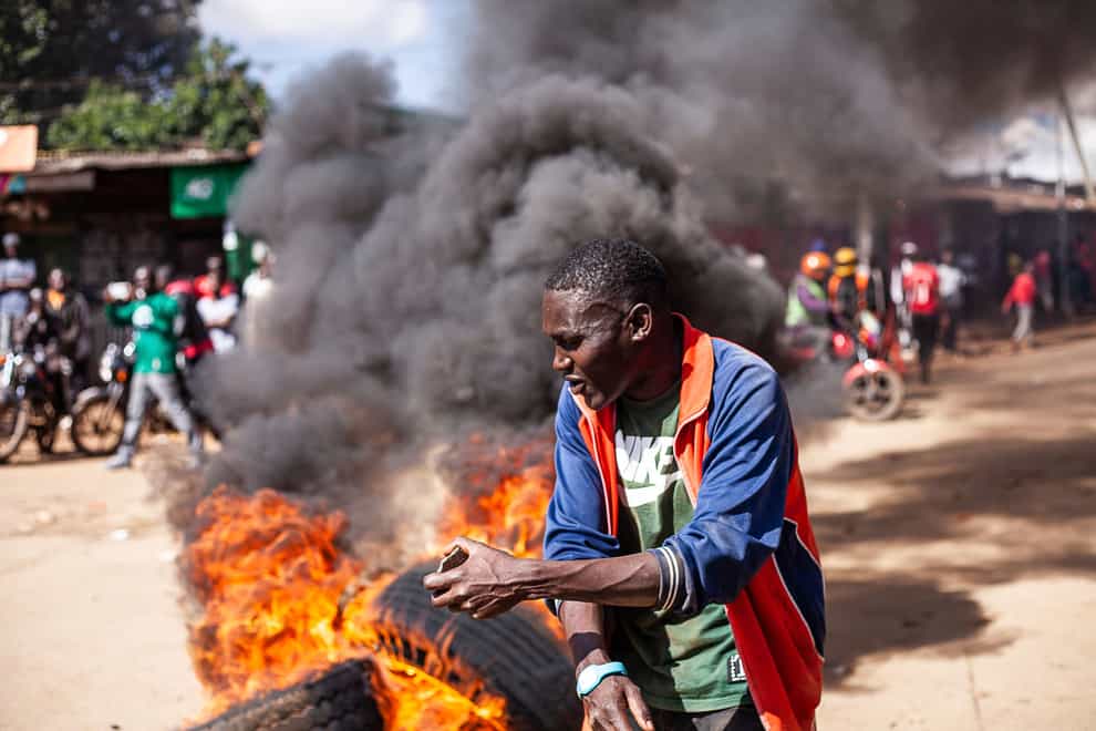 A protester reacts next to a burning barricade during a mass rally called by the opposition leader Raila Odinga (AP)