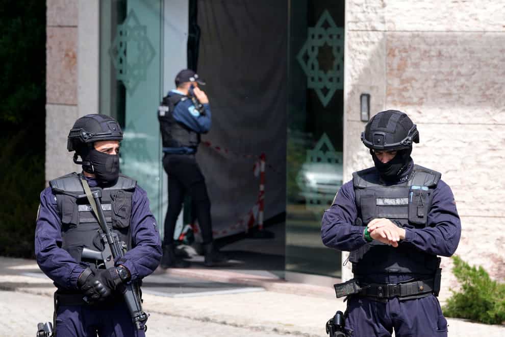 Police officers stand at the entrance of the Ismaili Muslim centre in Lisbon (Armando Franca/AP)