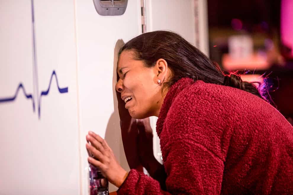 A woman cries while leaning on an ambulance as the immigration centre (Omar Ornelas/The El Paso Times via AP)
