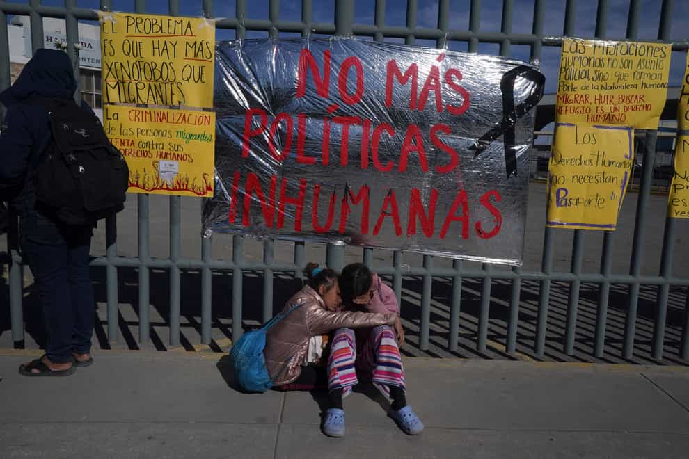 Venezuelan sisters comfort each other outside the immigration detention centre in Ciudad Juarez, Mexico (Fernando Llano/AP)