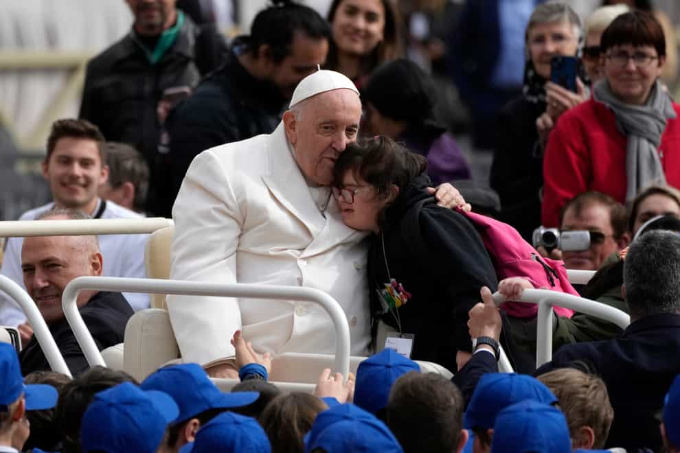 Pope Francis hugs a child at the end of his weekly general audience in St Peter’s Square, at the Vatican (AP Photo/Alessandra Tarantino)
