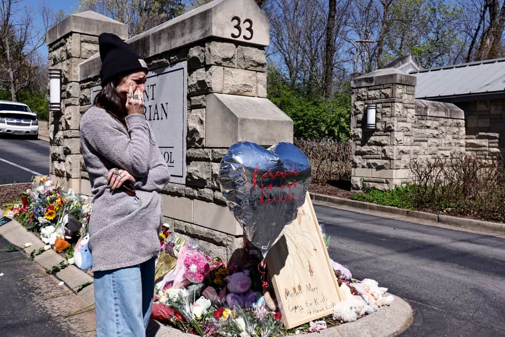 A woman wipes away tears as she visits a memorial at the entrance to the Covenant School (AP Photo/Wade Payne)