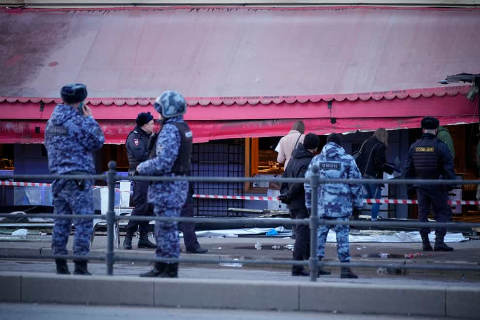 Russian police officers stand outside the cafe in St Petersburg (AP)