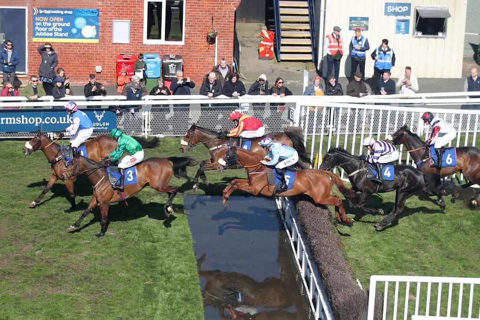 Annsam (red) jumps the water jump at Ludlow (Simon Marper/PA)