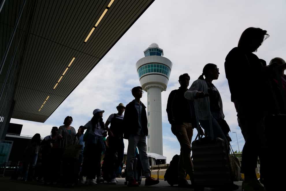 Passengers wait to board flights at Amsterdam’s Schiphol Airport (Peter Dejong/AP)