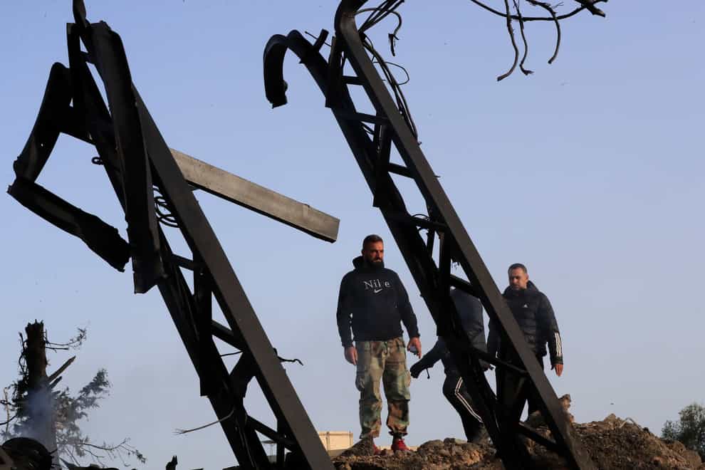 Lebanese check power transformer poles that were destroyed by an Israeli airstrike (Mohammad Zaatari/AP)