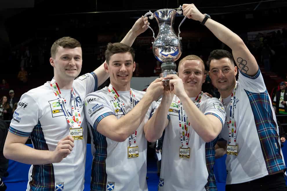 Bruce Mouat and team-mates Grant Hardie, Bobby Lammie and Hammy McMilllan, left to right, lift the World Championship trophy (Adrian Wyld /AP)