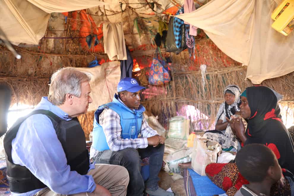Antonio Guterres talks to a Somali family through a translator in a refugee camp in Mogadishu (AP)