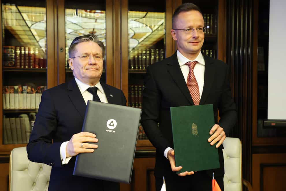 Alexey Likhachev, director general of state atomiс energy corporation Rosatom, left, and Peter Szijjarto, minister of foreign affairs and trade of Hungary pose after signing a document during their meeting in Moscow, Russia (Ivan Fedorenko/ Communications Department of Rosatom/AP)