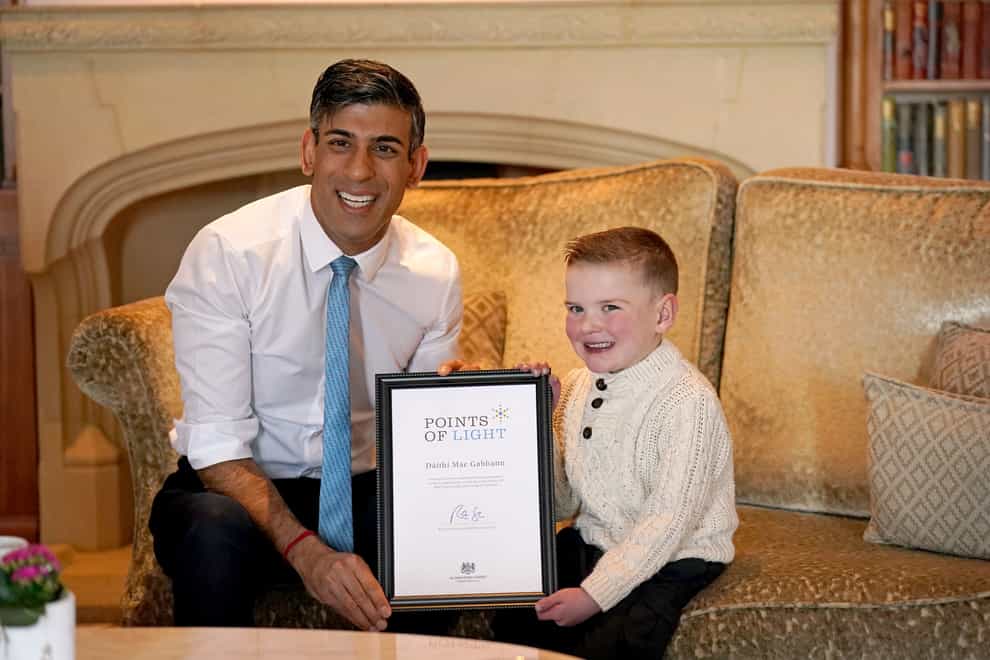 Prime Minister Rishi Sunak presents six-year-old Daithi Mac Gabhann, who is awaiting a heart transplant, with an award recognising “outstanding volunteers” for his contribution to his community during the Points of Light Awards held at the Culloden Hotel in Belfast (Niall Carson/PA)