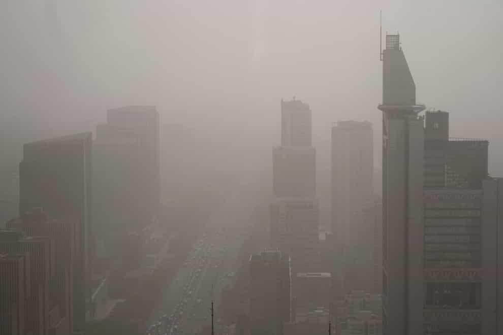 Buildings are shrouded in dust and sand in Beijing (Mark Schiefelbein/AP)