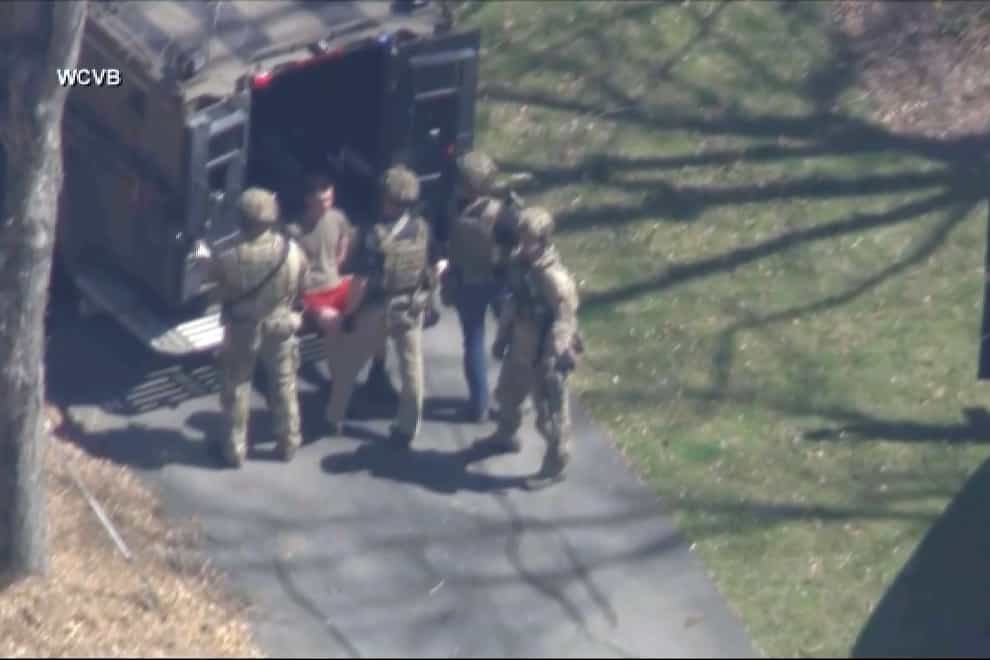 Jack Teixeira, in T-shirt and shorts, was taken into custody by armed tactical agents on Thursday (WCVB-TV via AP)