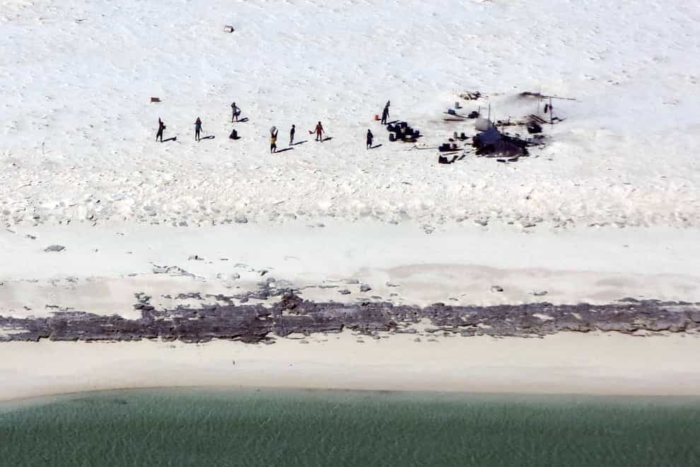 Fishermen from Indonesia stand on a beach on Bedwell Island, west of Broome, Australia (Australian Maritime Safety Authority via AP)