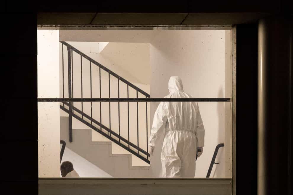 A member of the forensics team inspects the gym (dpa via AP)