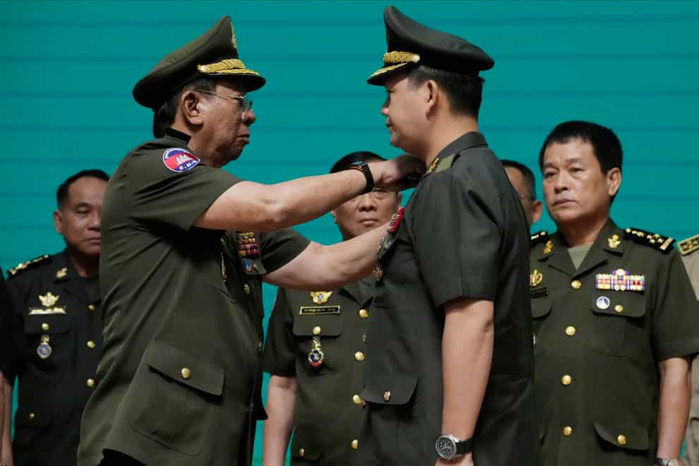 Cambodian army chief Hun Manet, right, receives the promotion to four-star general from minister Tea Banh (AP Photo/Heng Sinith)