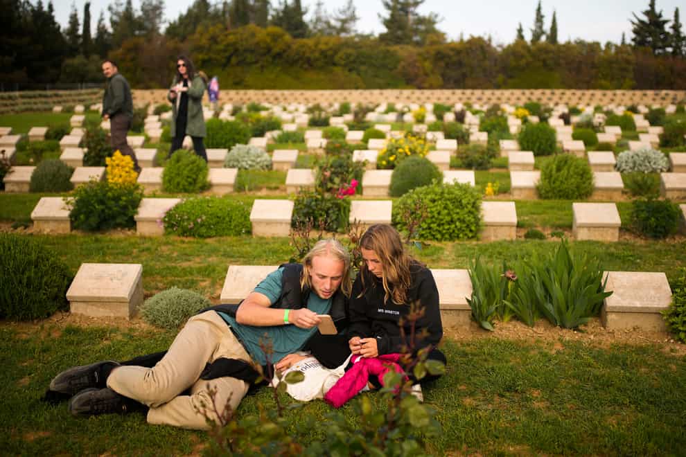 A couple sit among graves at the Lone Pine memorial cemetery after the dawn service ceremony at the Anzac Cove beach in Turkey (Emrah Gurel/AP)