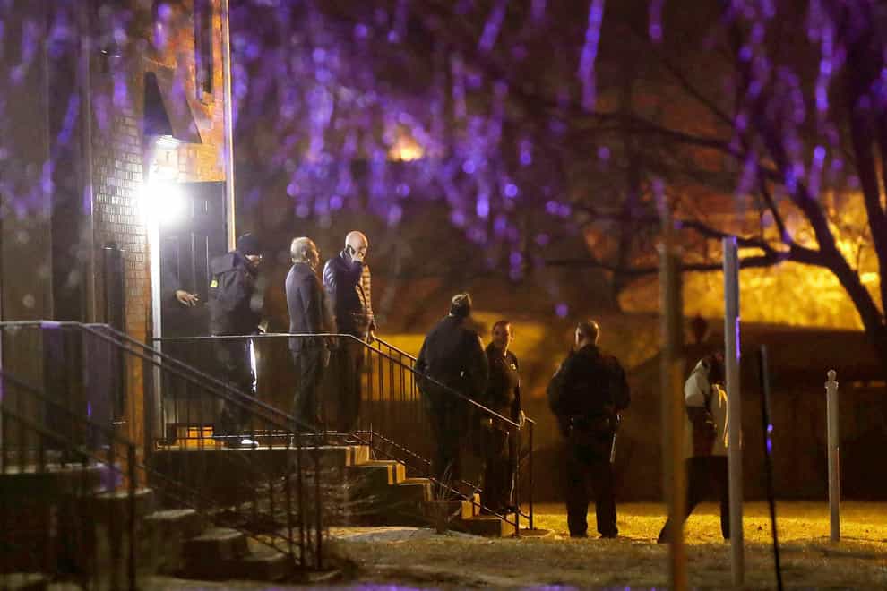 Officers walk out of the apartment complex where four people, one woman and three men, were found shot dead (Grace Hollars/The Indianapolis Star via AP, File)