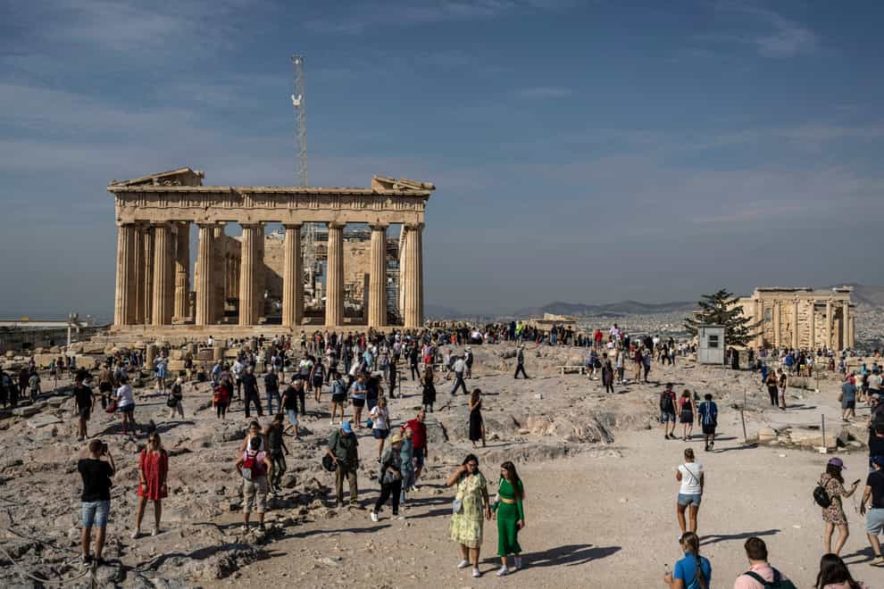 Tourists visit the Acropolis hill with the 2,500-year-old Parthenon temple on the left, and the ancient Erechtheion temple on the right, in Athens, Greece (Petros Giannakouris/AP)