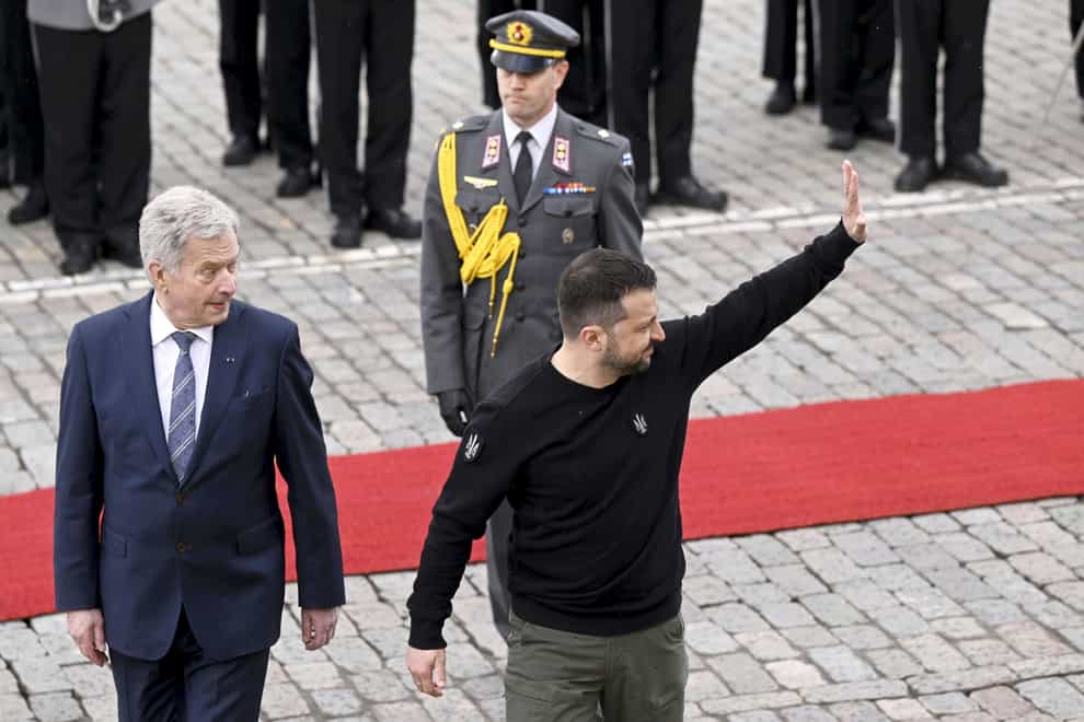 Ukrainian President Volodymyr Zelensky waves as he is welcomed by Finnish President Sauli Niinisto (AP)