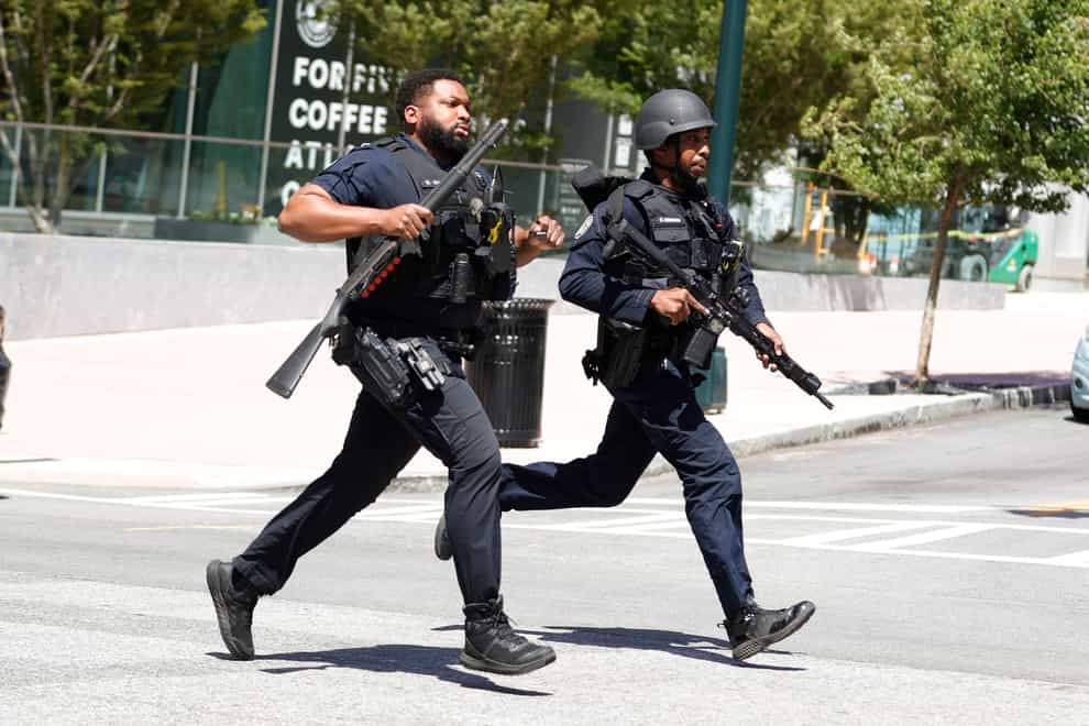 Law enforcement officers run near the scene of an active shooter on Wednesday, May 3, 2023 in Atlanta. Atlanta police said there had been no additional shots fired since the initial shooting unfolded inside a building in a commercial area with many office towers and high-rise apartments. (AP Photo/Alex Slitz)