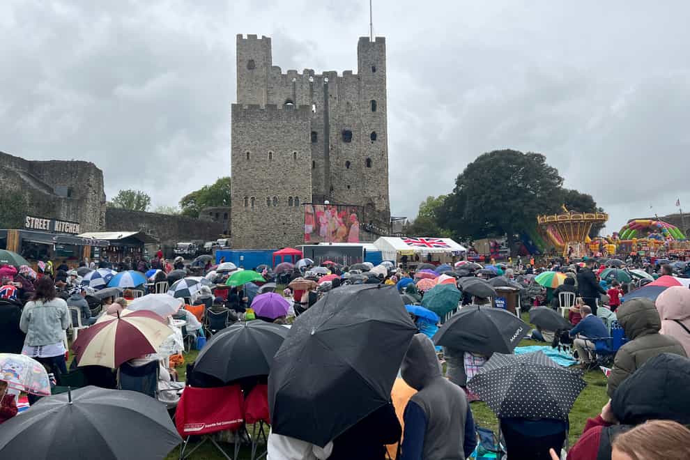 Members of the public watch a screening of the coronation on the lawn of Rochester Castle (Matilda Head/PA)
