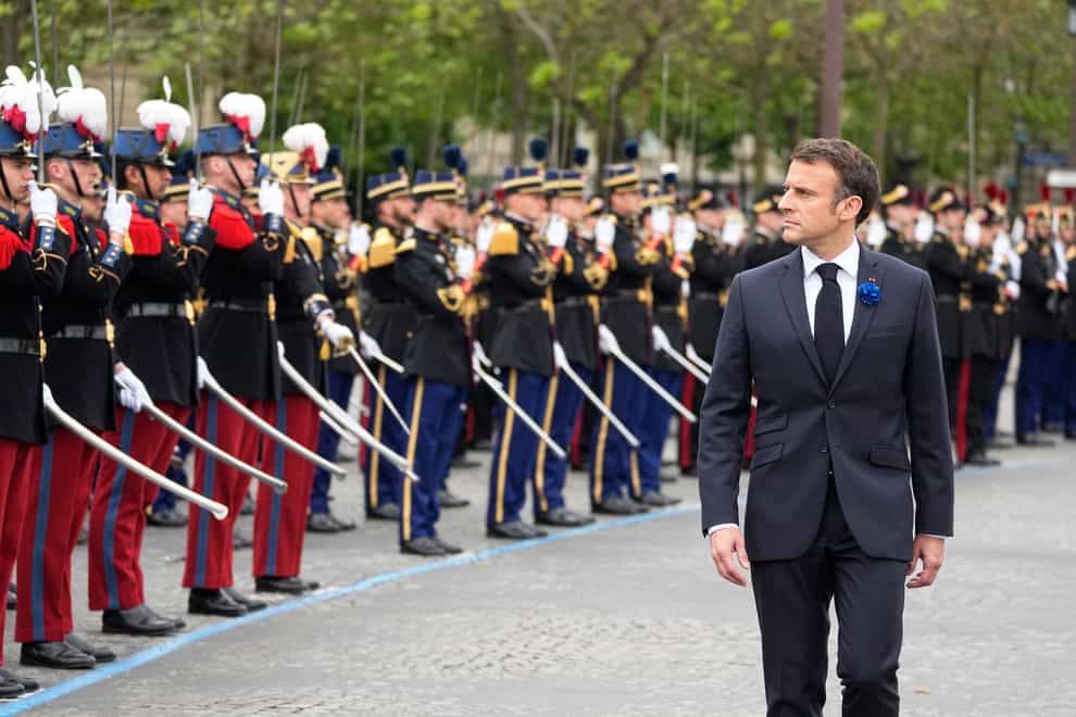French President Emmanuel Macron reviews the troops during ceremonies marking Victory Day in Paris (Michel Euler, Pool/AP)
