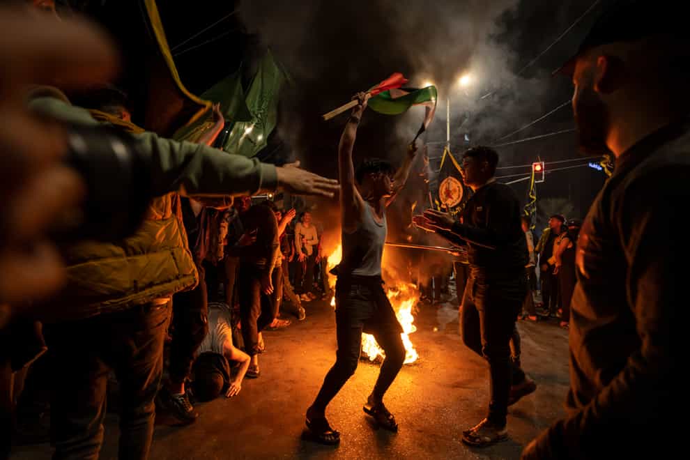 Palestinians celebrate the announcement of a ceasefire (Fatima Shbair/AP)
