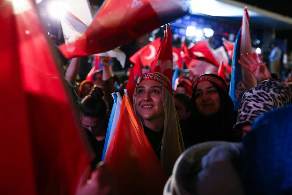 Supporters of Turkish President Recep Tayyip Erdogan wave flags outside the party headquarters in Ankara, Turkey, Sunday, May 14, 2023. Erdogan, who has ruled his country with an increasingly firm grip for 20 years, was locked in a tight election race Sunday, with a make-or-break runoff against his chief challenger possible as the final votes were counted. (AP Photo/Ali Unal)