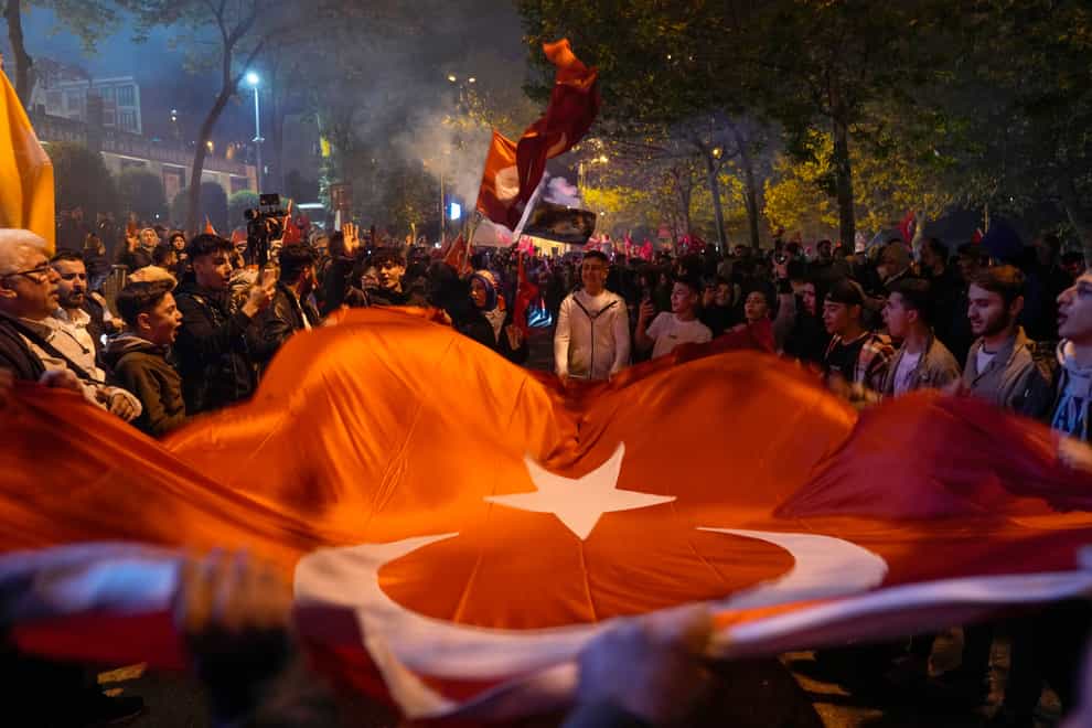 Supporters of President Recep Tayyip Erdogan celebrate outside AKP (Justice and Development Party) headquarters in Istanbul (Khalil Hamra/AP)