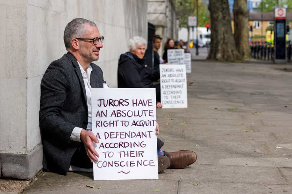 A group of 24 climate activists protested against the arrest of a fellow activist for showing this message to jurors (Zoe Broughton/PA)