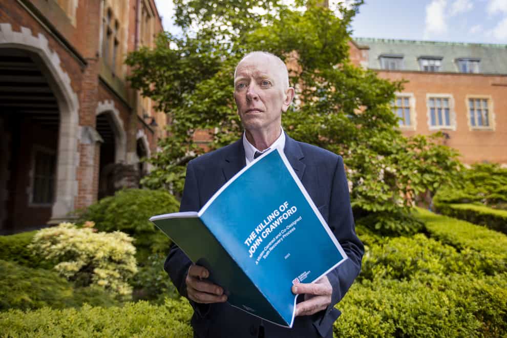 Paul Crawford holds a copy of a report by Queens University Belfast into the murder of his father John Crawford (Liam McBurney/PA)