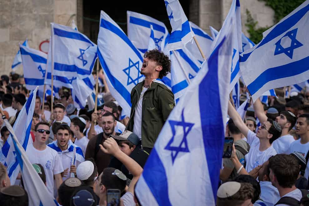 Israelis dance and wave national flags during a march marking Jerusalem Day (AP Photo/Ohad Zwigenberg)
