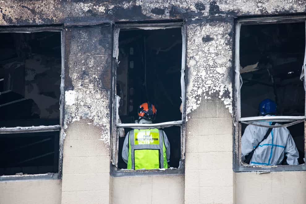 Fire and Police investigators inspect inside the Loafers Hostel in Wellington (New Zealand Herald via AP)