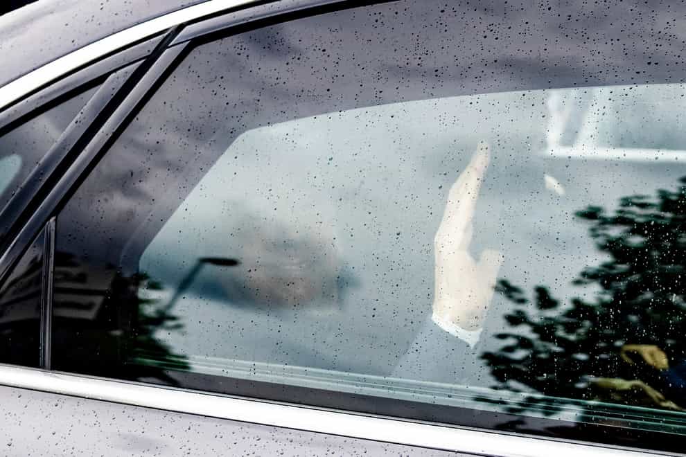 Silvio Berlusconi waves as his car speeds past (LaPresse via AP)