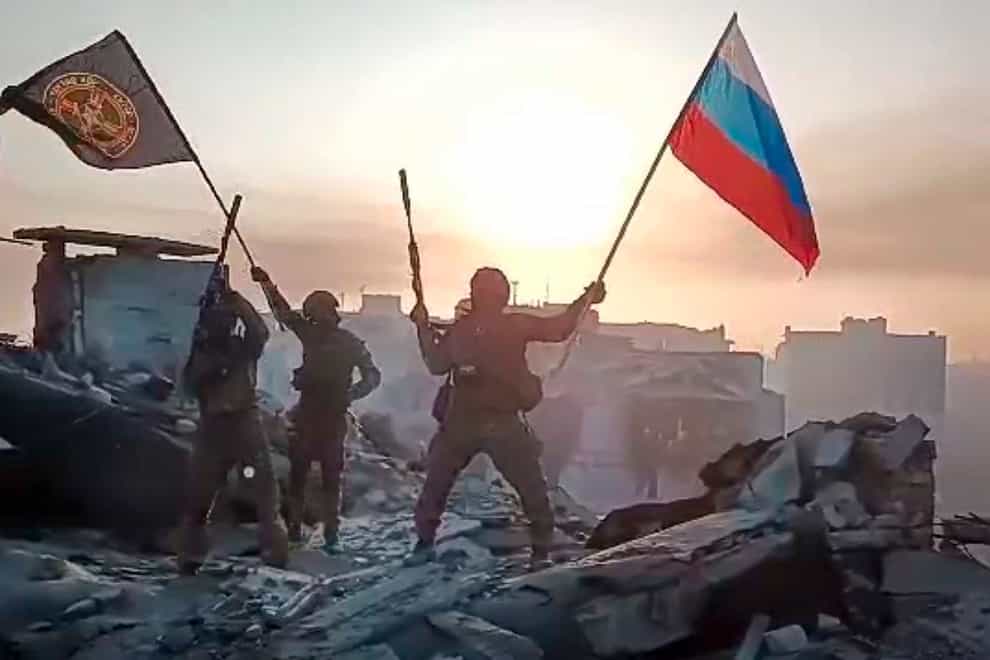 Yevgeny Prigozhin’s Wagner Group military company members wave a Russian national and Wagner flag atop a damaged building in Bakhmut, Ukraine. The head of the Russian private army Wagner claims his forces have taken control of the city of Bakhmut after the longest and most grinding battle of the Russia-Ukraine war, but Ukrainian defense officials have denied it. In a video posted on Telegram, Prigozhin said the city came under complete Russian control at about midday Saturday. (Prigozhin Press Service via AP)
