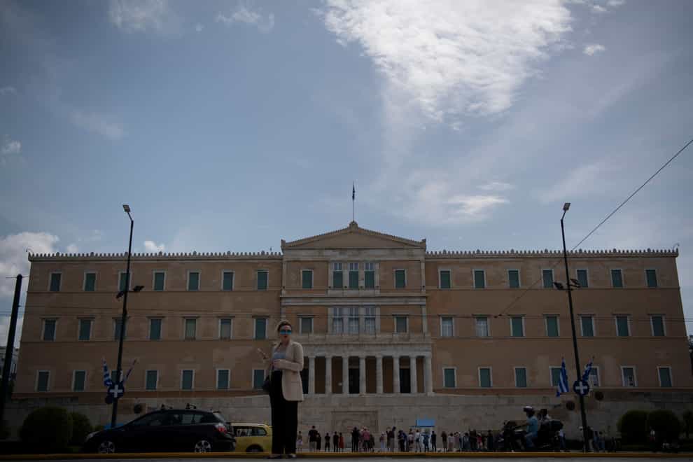 A woman stands in front of the parliament, in Athens, Greece, Saturday, May 20, 2023, a day before the general elections. Sunday’s Greek parliamentary election looks likely to be a dress rehearsal for a new round of voting in the busy summer tourist season — barring a surprise coalition deal by dissonant opposition parties. (Michael Varaklas, AP)