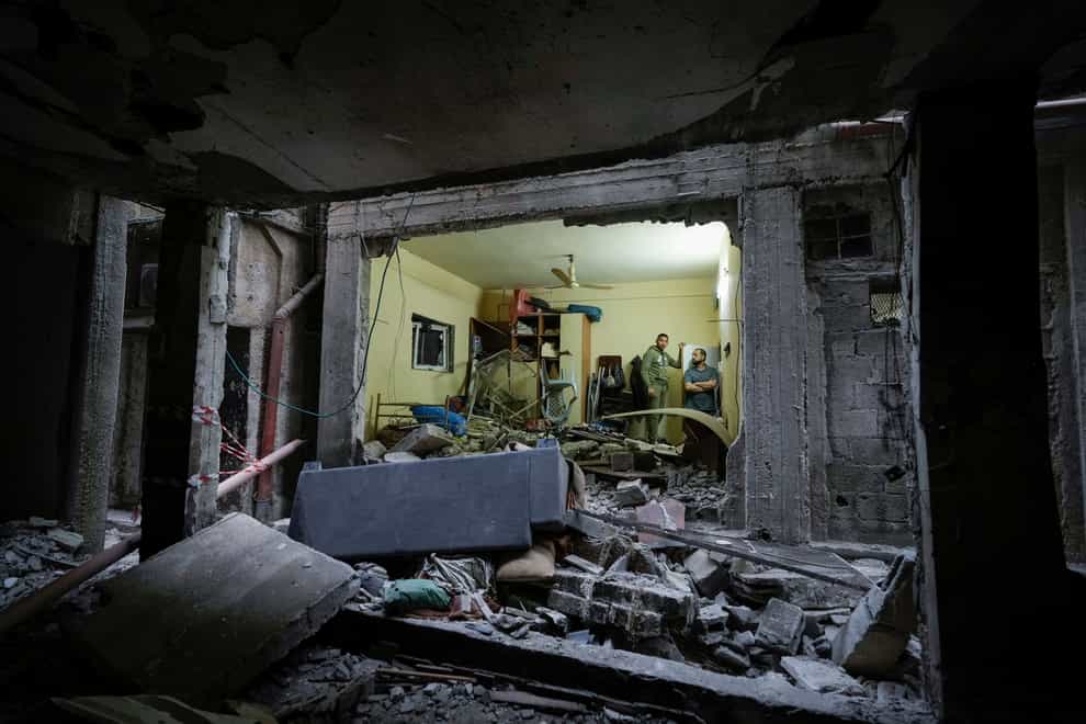 Palestinians inspect a damaged building following an Israeli army raid in the Balata refugee camp (Majdi Mohammed/AP)