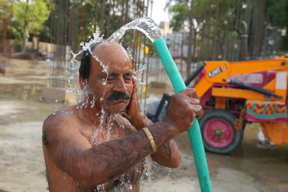 An Indian worker pours water on himself at a construction site (Rajesh Kumar Singh/AP)